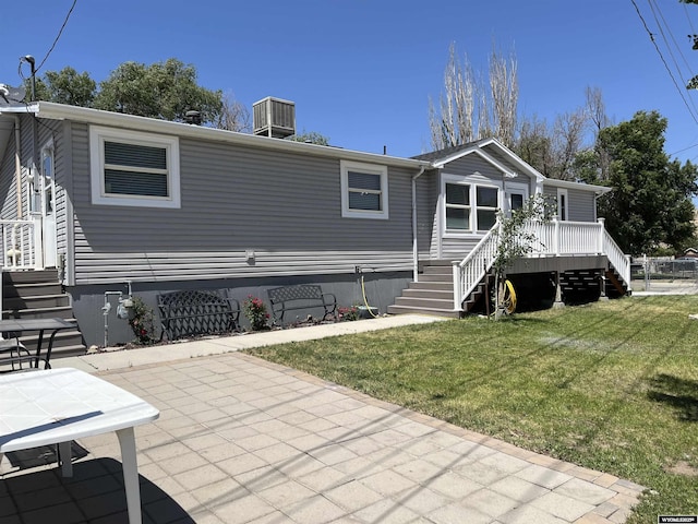703 Randolph St, Rock Springs, WY 82901 - back of property featuring stairs, a lawn, a wooden deck, and a patio