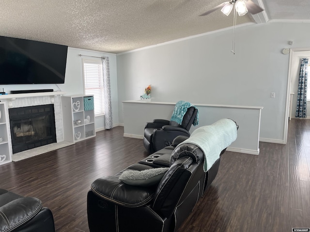703 Randolph St, Rock Springs, WY 82901 - living room featuring wood finished floors, a ceiling fan, a tiled fireplace, a textured ceiling, and vaulted ceiling