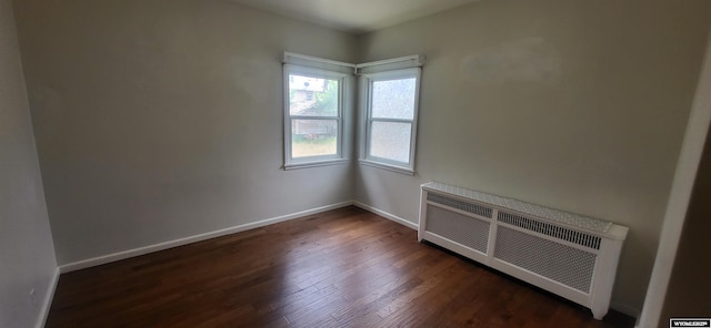 222 E Maple St, Rawlins, WY 82301 - empty room with radiator heating unit and dark wood-style flooring
