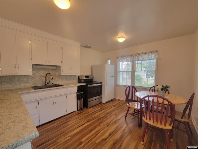 1031 Mckinley Ave, Rock Springs, WY 82901 - kitchen with stainless steel electric range, wood finished floors, light countertops, white cabinets, and freestanding refrigerator