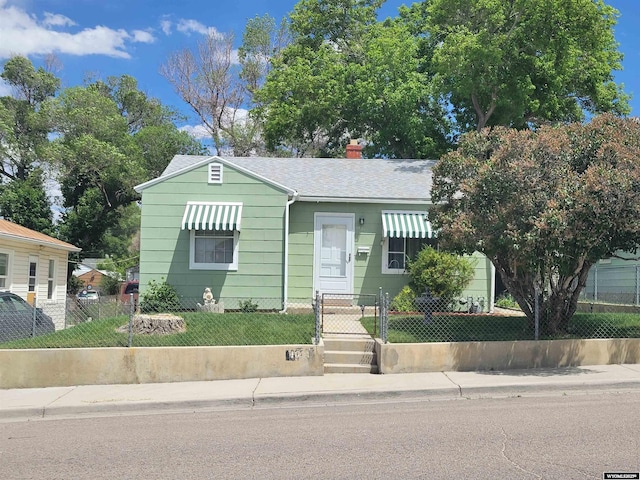 1031 Mckinley Ave, Rock Springs, WY 82901 - bungalow-style home featuring a fenced front yard, a shingled roof, a gate, and a chimney