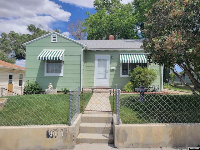1031 Mckinley Ave, Rock Springs, WY 82901 - bungalow-style house featuring a fenced front yard, a gate, a shingled roof, and a chimney