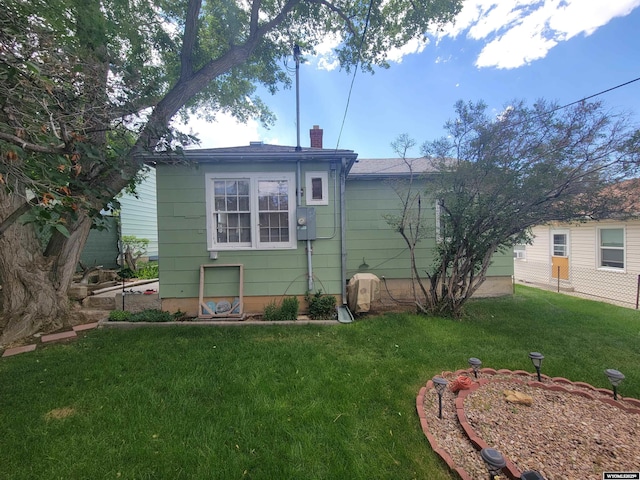 1031 Mckinley Ave, Rock Springs, WY 82901 - back of property with a lawn and a chimney