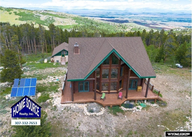 11 Heather Ln, Lander, WY 82520 - rear view of property with ground mounted solar panels, a view of trees, and a shingled roof