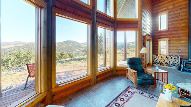 11 Heather Ln, Lander, WY 82520 - sunroom with a mountain view, rustic walls, a high ceiling, a wood stove, and tile patterned floors