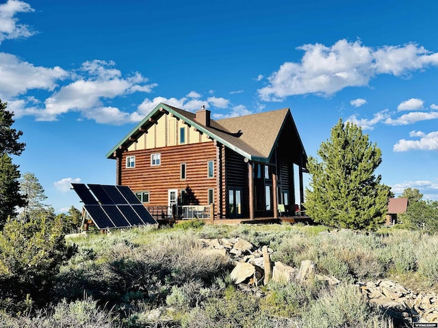 11 Heather Ln, Lander, WY 82520 - rear view of property with ground mounted solar panels, board and batten siding, and a chimney