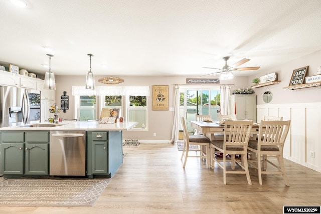 750 N Adams Ave, Buffalo, WY 82834 - kitchen with stainless steel appliances, green cabinets, ceiling fan, light wood finished floors, and light countertops