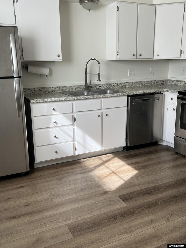721 Sioux, Evanston, WY 82930 - kitchen featuring appliances with stainless steel finishes, white cabinets, and dark wood-style floors