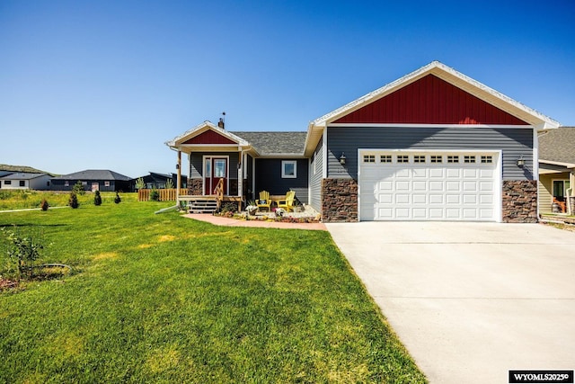 1343 Silverton Dr, Ranchester, WY 82839 - view of front of house with driveway, an attached garage, stone siding, and a front lawn