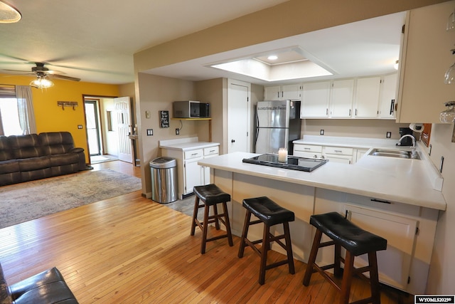 609 Klondike Dr, Buffalo, WY 82834 - kitchen with freestanding refrigerator, a peninsula, light wood-type flooring, and light countertops