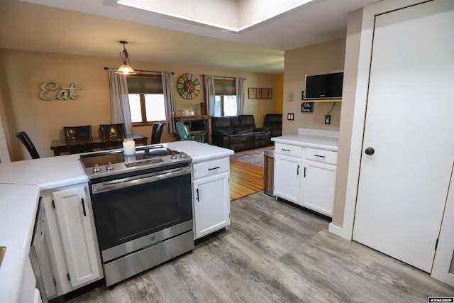 609 Klondike Dr, Buffalo, WY 82834 - kitchen featuring stainless steel range with electric cooktop, light wood finished floors, white cabinets, and open floor plan