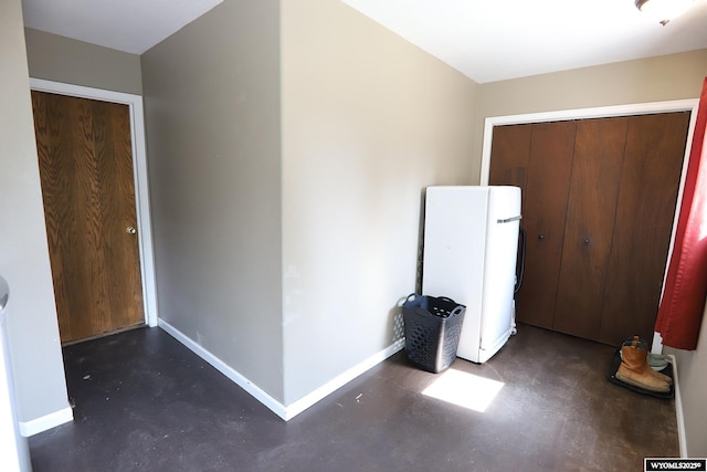 609 Klondike Dr, Buffalo, WY 82834 - unfurnished bedroom featuring concrete flooring, freestanding refrigerator, and a closet