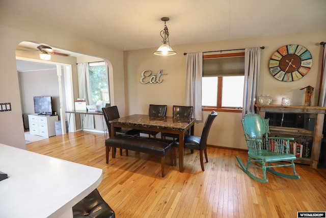 609 Klondike Dr, Buffalo, WY 82834 - dining space featuring arched walkways, light wood-style flooring, and healthy amount of natural light
