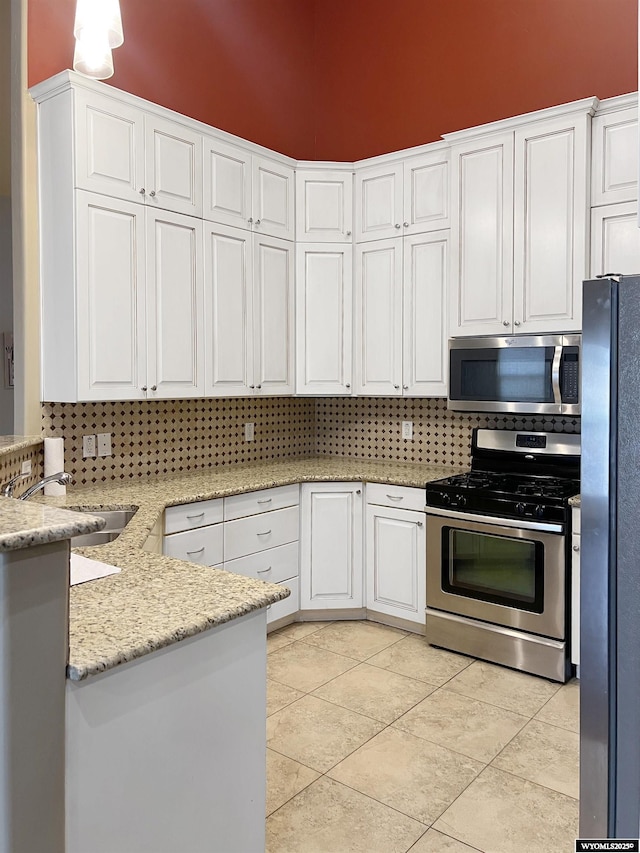 155 Highridge Pt, Evanston, WY 82930 - kitchen with appliances with stainless steel finishes, white cabinets, tasteful backsplash, and light tile patterned floors