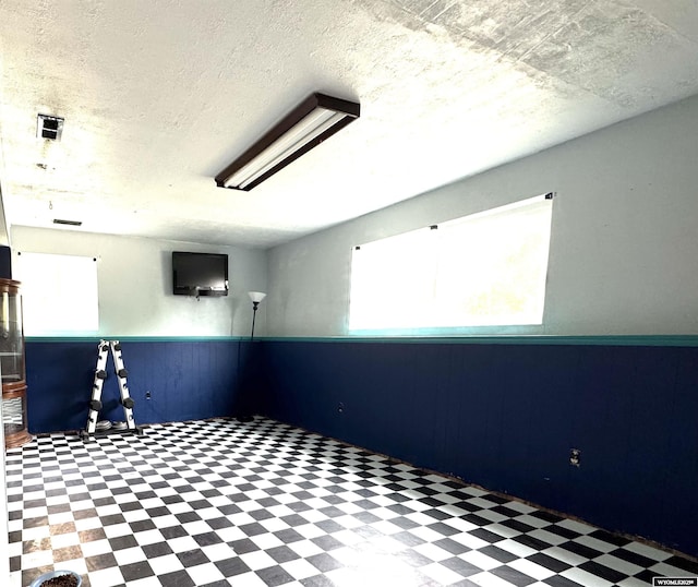331 Hansen Ave, Evanston, WY 82930 - spare room with tile patterned floors, healthy amount of natural light, wainscoting, and wooden walls
