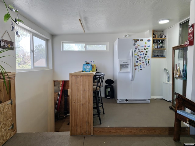 313 Cottonwood St, Evanston, WY 82930 - kitchen featuring white refrigerator with ice dispenser and a textured ceiling