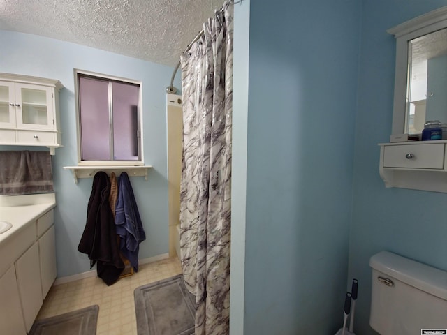313 Cottonwood St, Evanston, WY 82930 - bathroom with tile patterned floors, vanity, a textured ceiling, and a shower with curtain