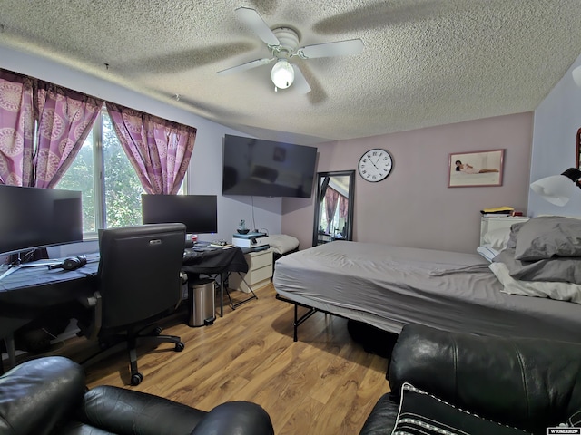 313 Cottonwood St, Evanston, WY 82930 - bedroom with a textured ceiling, light wood-style flooring, a ceiling fan, and a desk