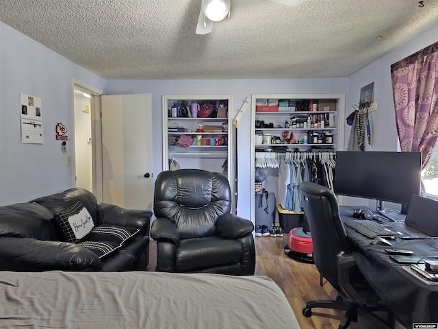 313 Cottonwood St, Evanston, WY 82930 - bedroom with wood finished floors, a textured ceiling, an office area, and multiple closets