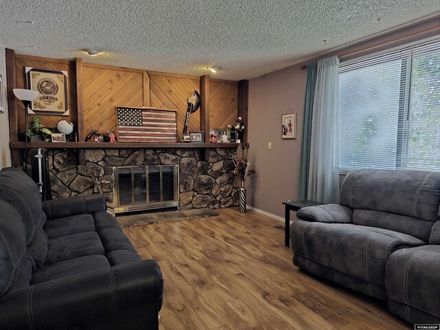 313 Cottonwood St, Evanston, WY 82930 - living area with a textured ceiling, wood finished floors, and a stone fireplace