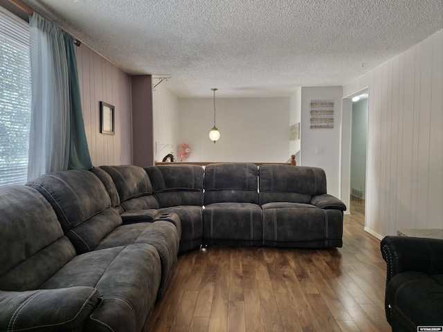 313 Cottonwood St, Evanston, WY 82930 - living area featuring wood walls, dark wood-style floors, and a textured ceiling