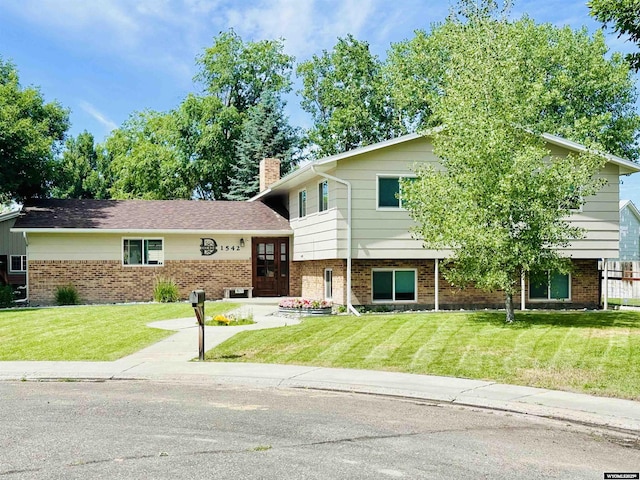 1542 Cloud Peak Dr, Worland, WY 82401 - tri-level home featuring a front yard, brick siding, and a chimney