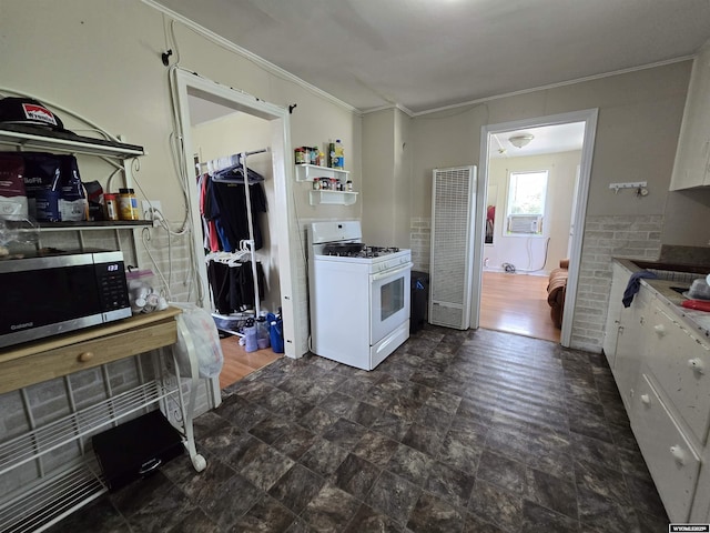 251 S Nebraska Ave, Guernsey, WY 82214 - kitchen featuring gas range gas stove, a heating unit, stainless steel microwave, ornamental molding, and cooling unit