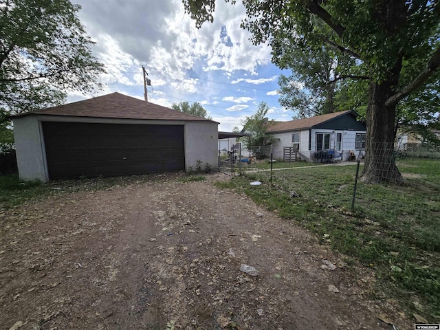 251 S Nebraska Ave, Guernsey, WY 82214 - view of side of home with a garage, stucco siding, and an outdoor structure