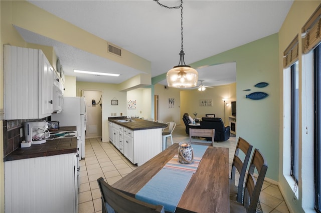 dining room with ceiling fan, sink, and light tile patterned flooring