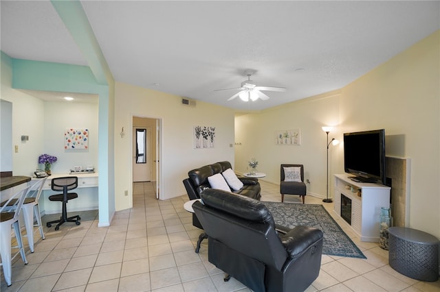 tiled living room with built in desk and ceiling fan