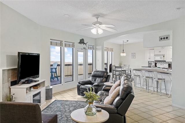 tiled living room with a textured ceiling and ceiling fan