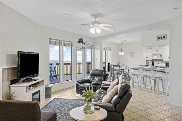 6317 State Highway 361 Unit 3311, Port Aransas, TX 78373 - living room with arched walkways, light tile patterned floors, a ceiling fan, and a textured ceiling