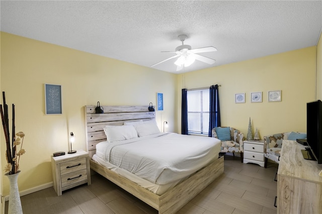 bedroom with a textured ceiling and ceiling fan