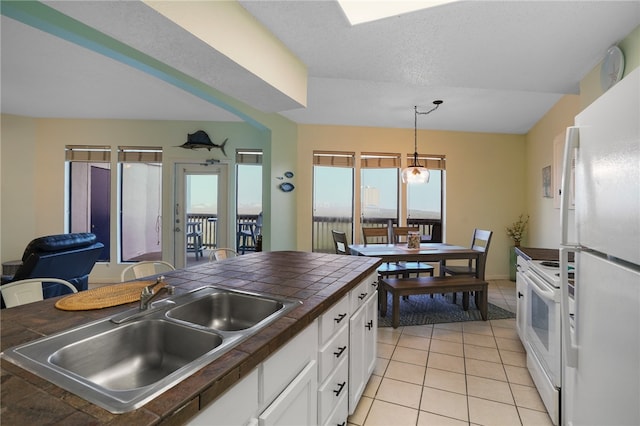 kitchen featuring white cabinetry, light tile patterned floors, pendant lighting, sink, and white appliances