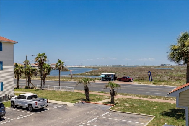 uncovered parking lot featuring a water view