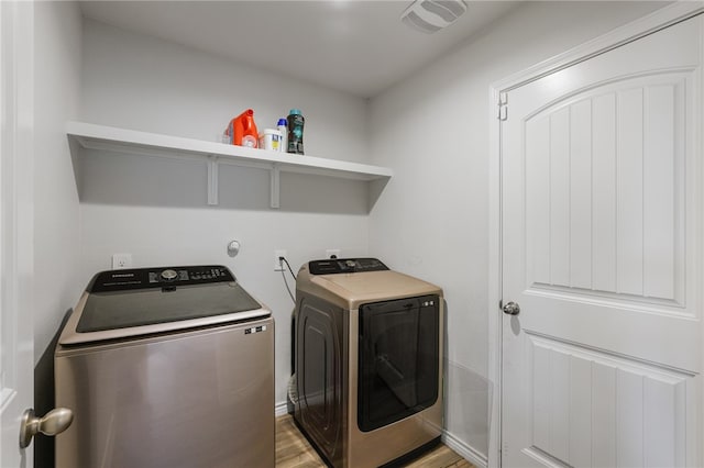 laundry area featuring light wood-type flooring and washing machine and clothes dryer