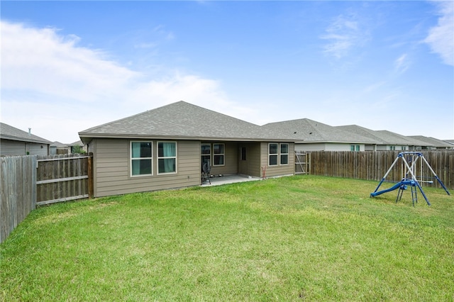 back of house with a patio area, a lawn, and a playground