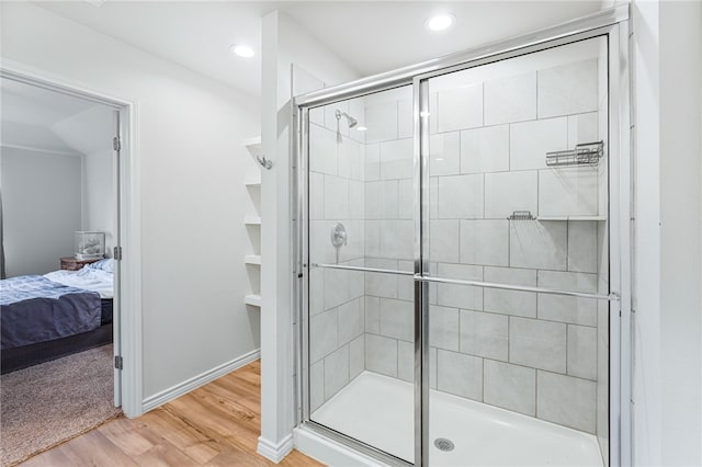 bathroom with hardwood / wood-style floors and a shower with door