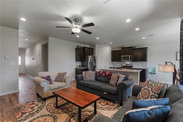 living room featuring ceiling fan and dark hardwood / wood-style flooring