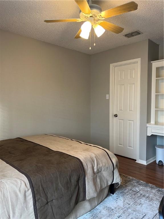 bedroom featuring hardwood / wood-style flooring, ceiling fan, and a textured ceiling