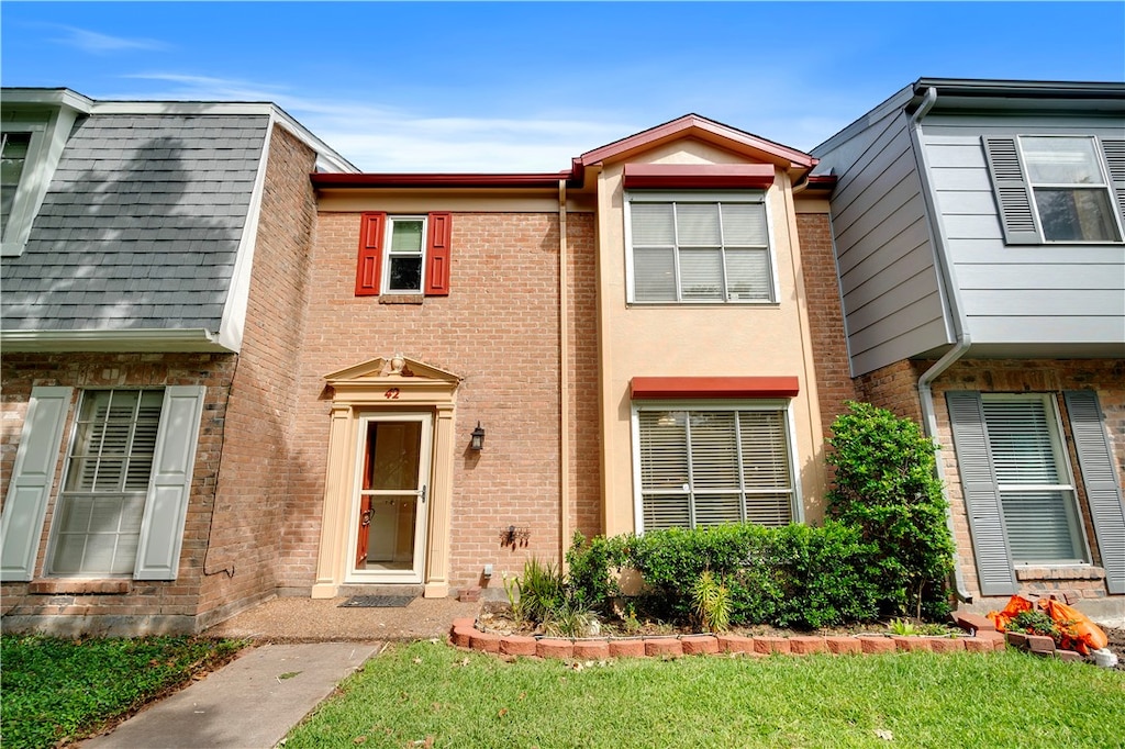 townhome / multi-family property featuring a front yard