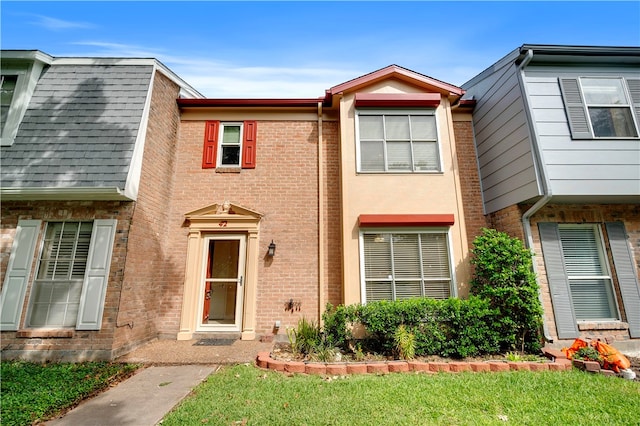 townhome / multi-family property featuring a front yard