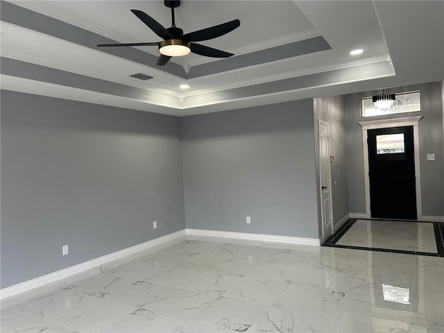 foyer featuring a raised ceiling, ornamental molding, and ceiling fan