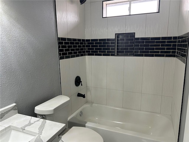 full bathroom featuring vanity, tiled shower / bath combo, and toilet