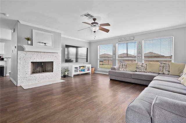 living room featuring crown molding, dark wood-type flooring, ceiling fan, and a fireplace