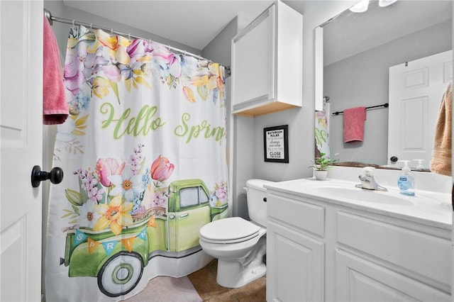 bathroom featuring tile patterned floors, toilet, curtained shower, and vanity