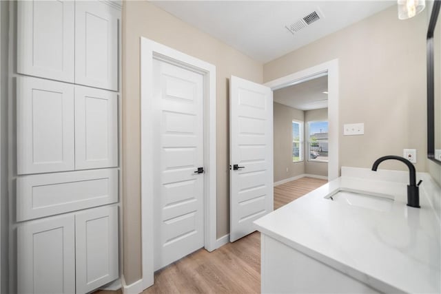 bathroom with visible vents, baseboards, wood finished floors, and vanity