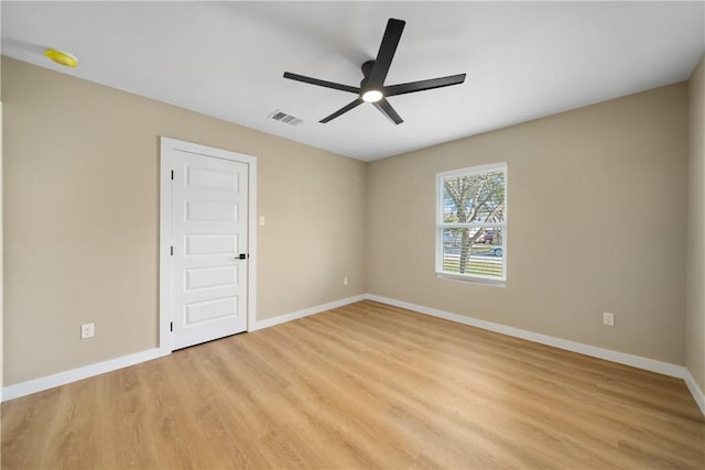 spare room featuring light wood-style flooring, baseboards, visible vents, and ceiling fan