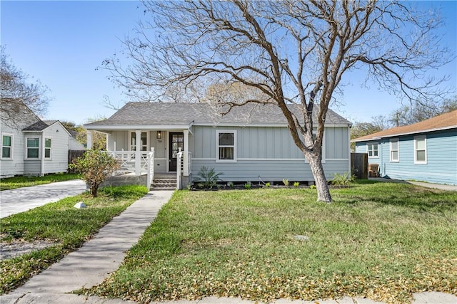 view of front facade featuring board and batten siding, a porch, and a front yard