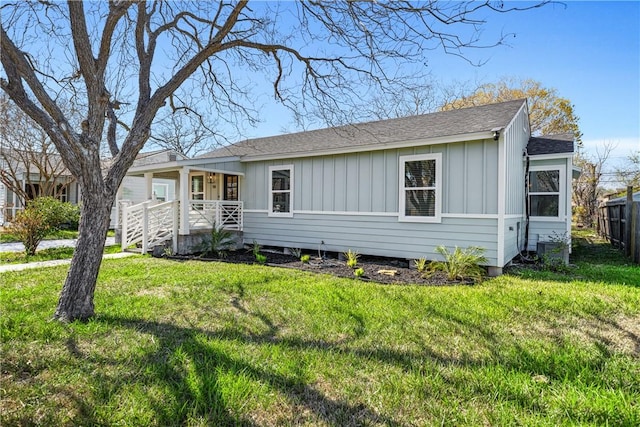 view of front of house with a porch, fence, a front lawn, and board and batten siding